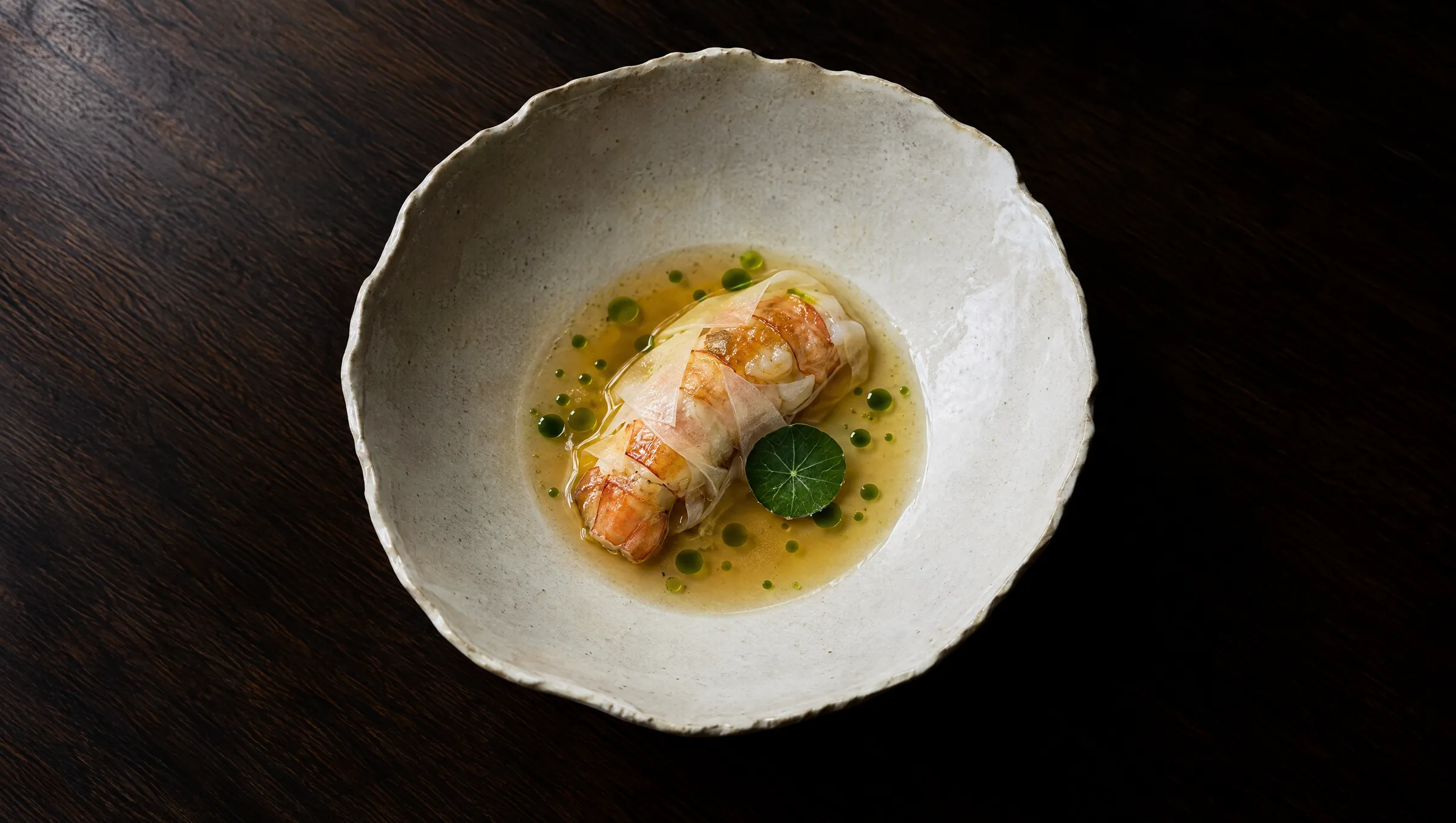Langoustine in Kohlrabi gehüllt, in klarer Dashi mit Schnittlauchöl